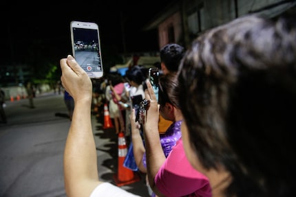 Onlookers watch and cheer as ambulances transport some of the rescued schoolboys from a...