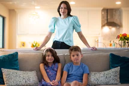 Tori Jones stands in her living room with her children Quinn and Max, both 8, at their home...
