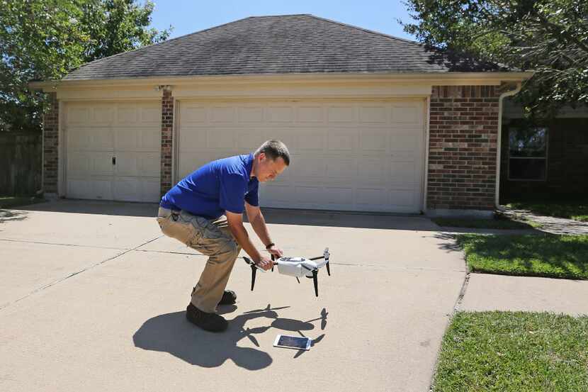 Farmers Insurance claims representative Brent Hazen gets ready to use a drone to make a...