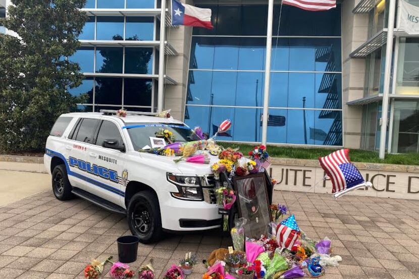 Toys, flowers and other offerings covered a Mesquite police car Tuesday in memory of Kozmo,...