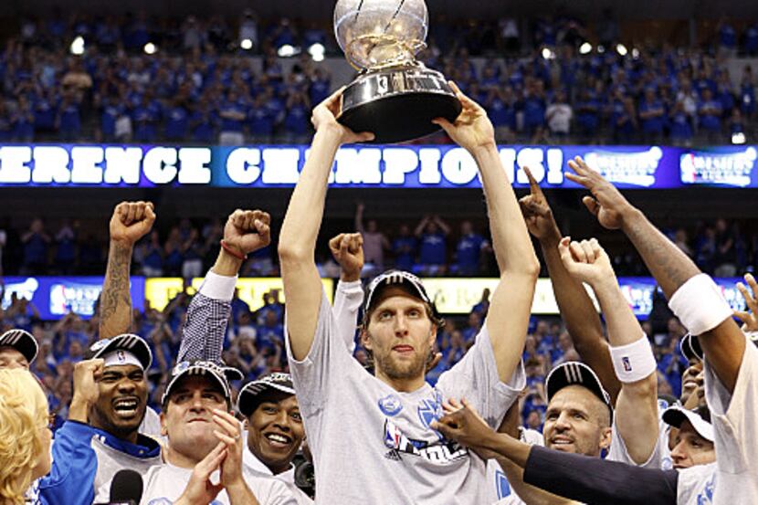 Dallas Mavericks power forward Dirk Nowitzki (41) holds up the trophy as teammates celebrate...