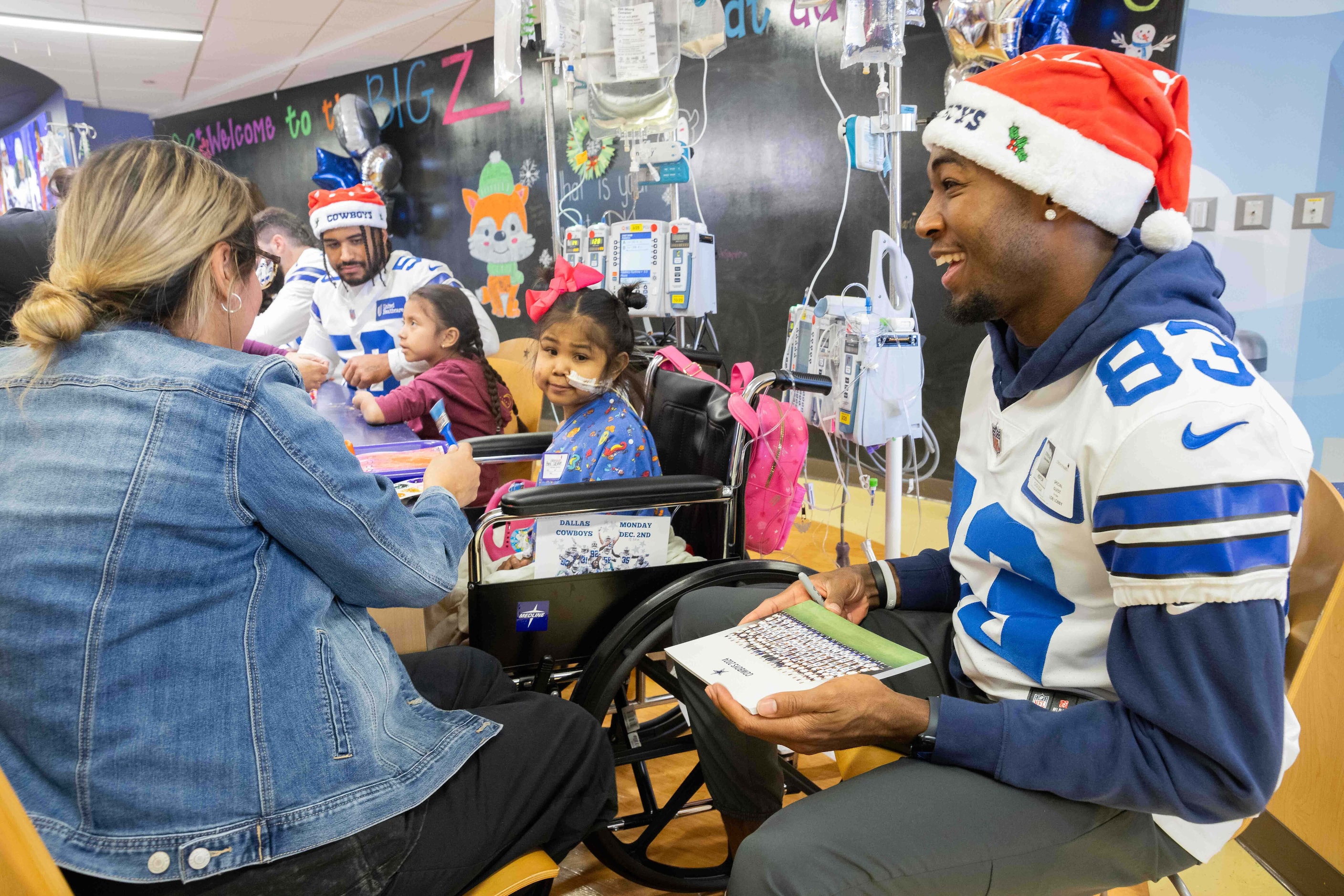 Dallas Cowboys wide receiver Jalen Brooks (83) shares a laugh with Hope Castanon, 7, and her...