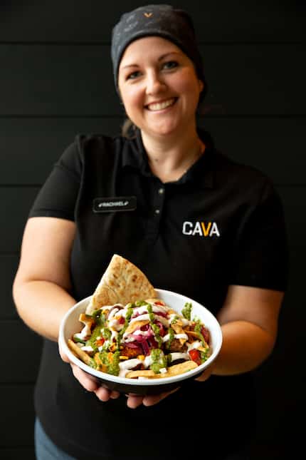 Rachael Lawler, general manager at Cava, holds a custom bowl with pita bread at the new...