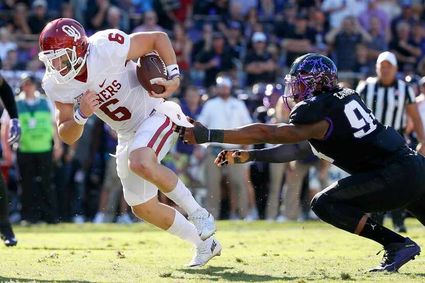 Oklahoma quarterback Baker Mayfield (6) gets away from a tackle by TCU defensive end Josh...