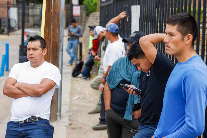 Day laborers wait by a Valero gas station along Esperanza Road, hoping to get hired for a...