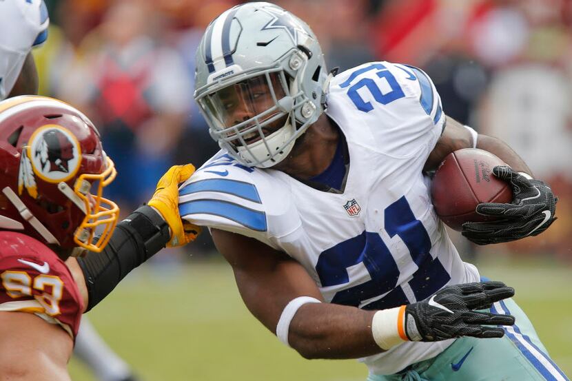 Dallas Cowboys running back Ezekiel Elliott (21) is dragged down by Washington Redskins...