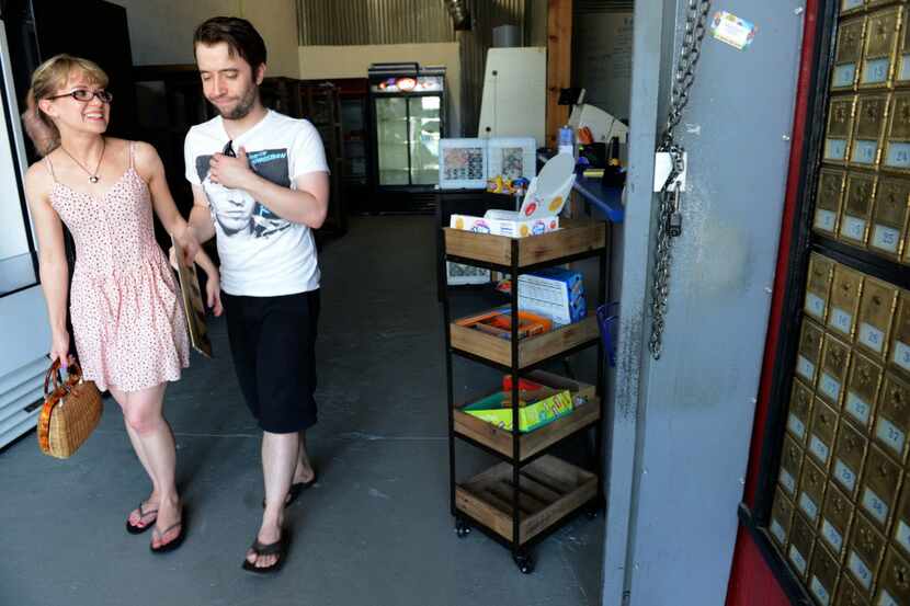 Alexis Clare and Andrew Strickland walk out of the Deep Ellum Postal and Grocer after...