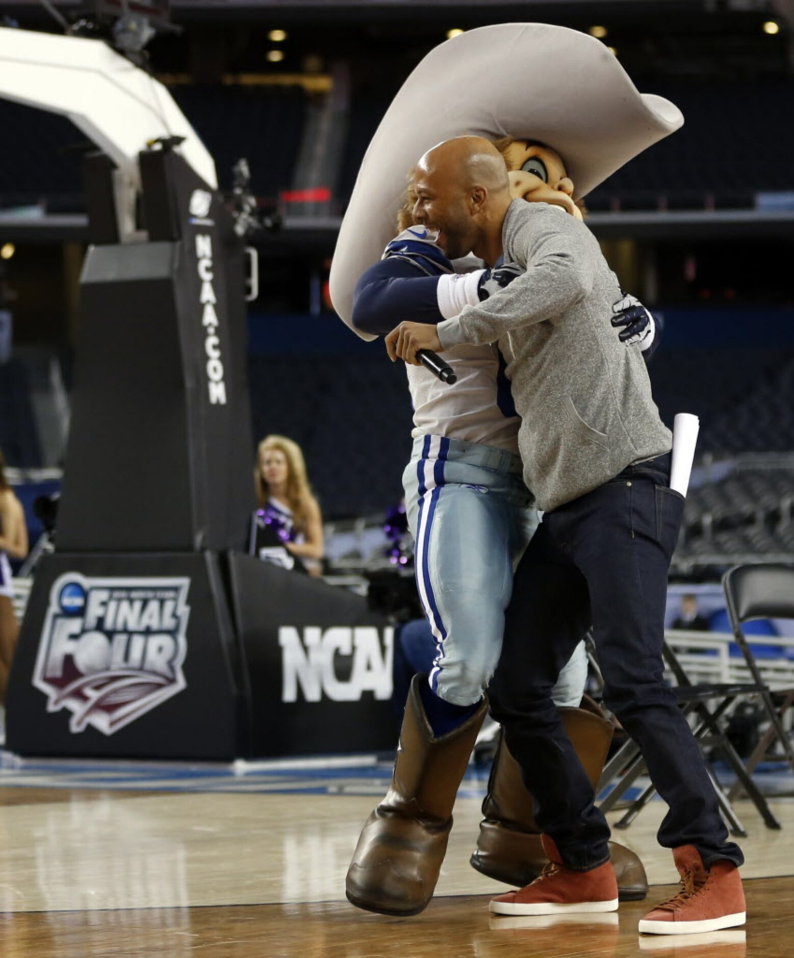 Common gets a hug from Dallas Cowboys Rowdy during the Reese's Final Four Slant Celebration...