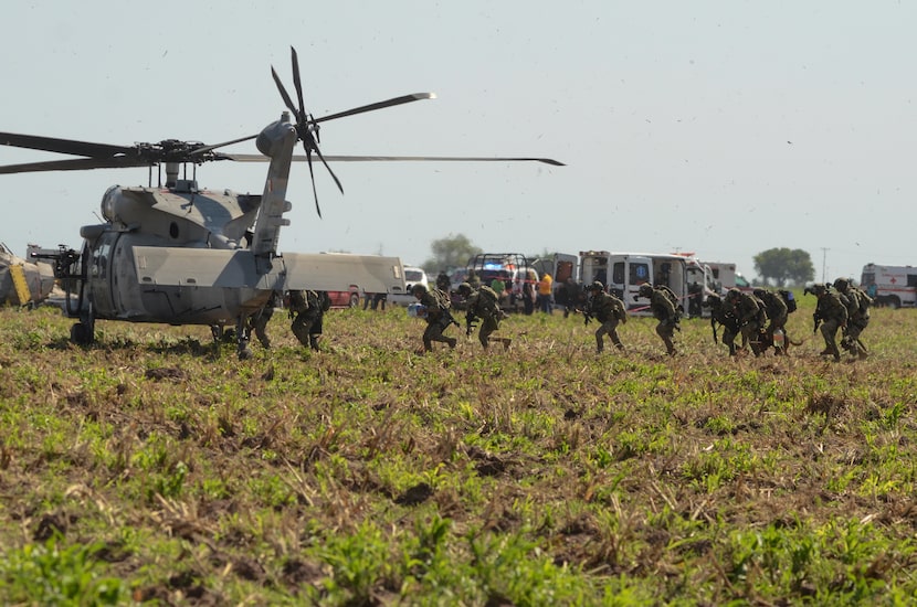 Mexican marines board a helicopter after working on the zone where other navy Blackhawk...