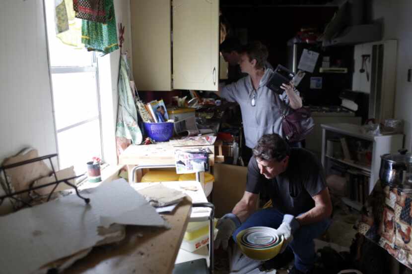 Louie Webre and Susan Knapek sort through their kitchen cabinets after being let into their...
