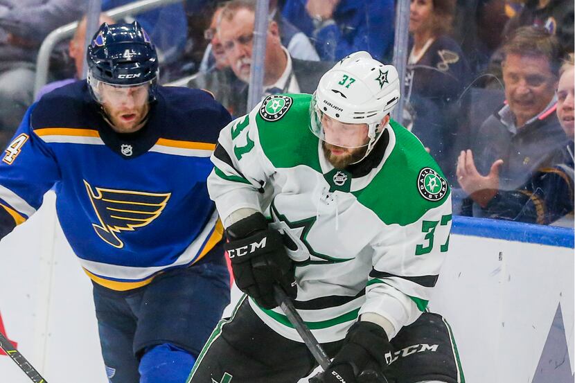 Dallas Stars center Justin Dowling (37) looks to make a pass as he is defended by St. Louis...