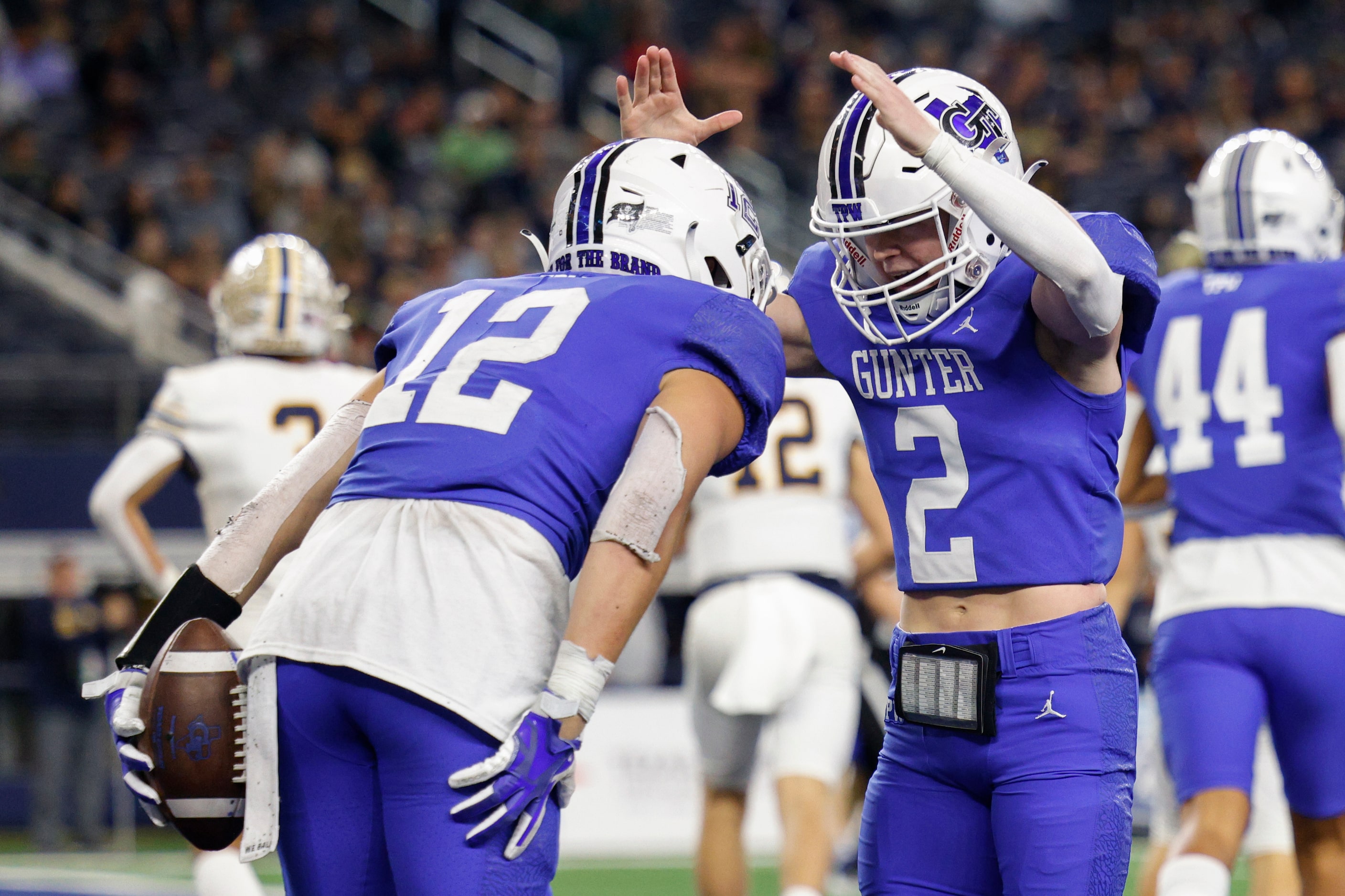 Gunter quarterback Walker Overman (2) crowns running back Ivy Hellman (12) after Hellman...