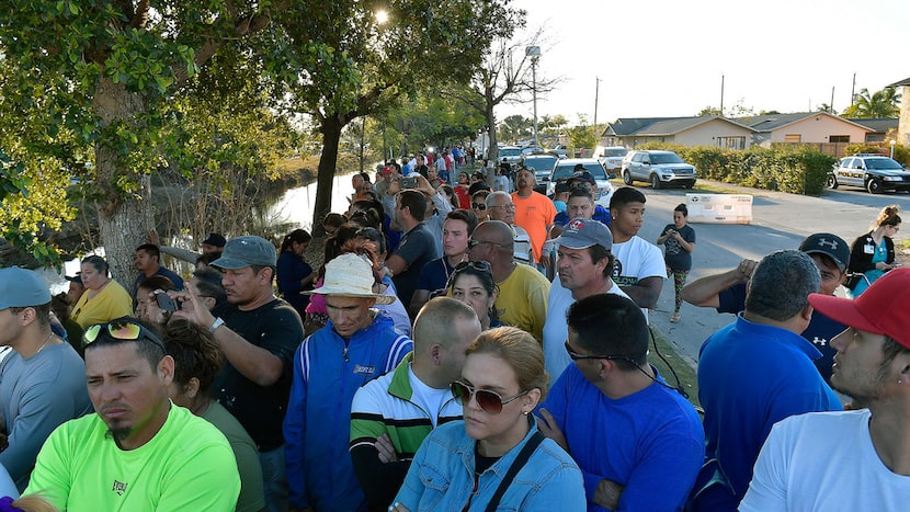 Miami residents watch rescue crews work after a brand new, 950-ton pedestrian bridge...