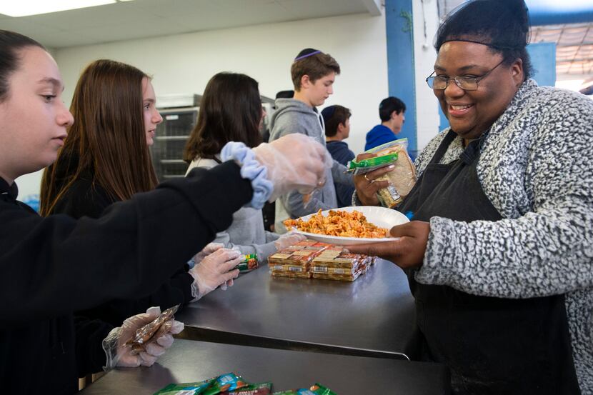 Fourteen-year-old Gabby Ido served lunch to a resident at the Austin Street Center shelter...