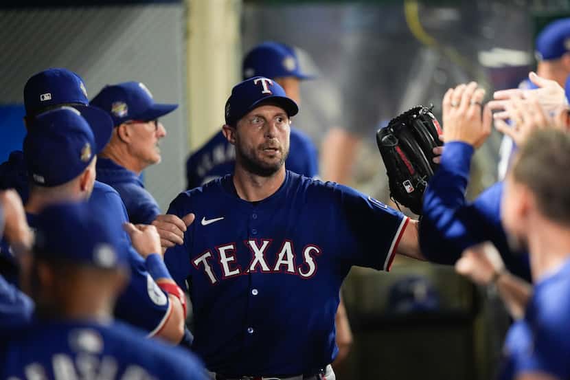 Texas Rangers starting pitcher Max Scherzer high-fives teammates after being replaced during...