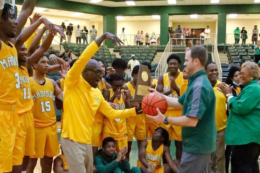 Madison head coach Damien Mobley receives the trophy and game ball after his victory in the...