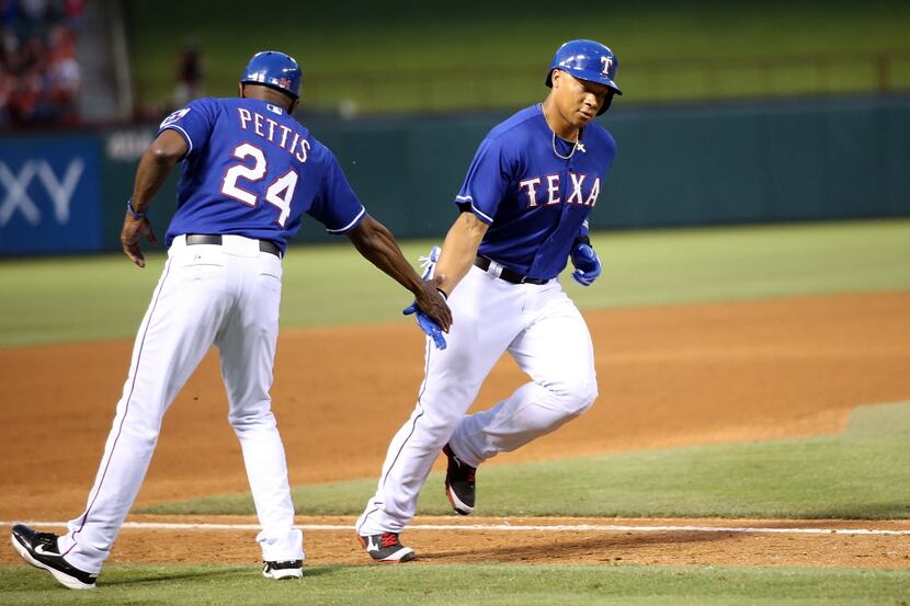 ARLINGTON, TX - JUNE 9:  Michael Choice #15 of the Texas Rangers is congratulated by third...