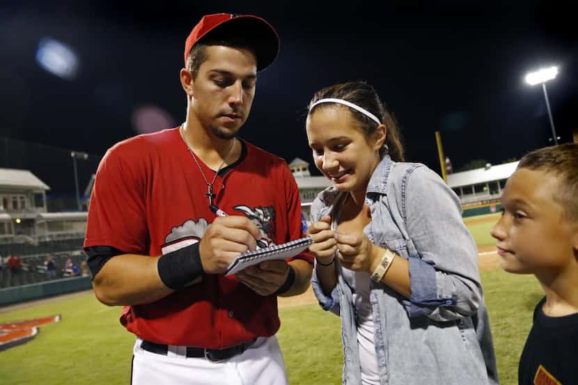 Jake Skole (left) signs an autograph for Angel Brazier, 13, after taking the ALS ice water...