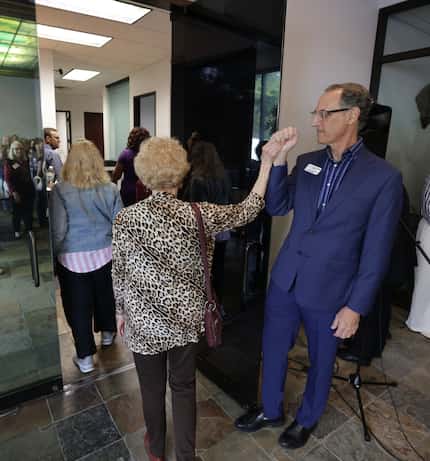 Daleen Maxwell, left, gives a high five to Rev. Dr. Daniel Kanter during a grand opening...