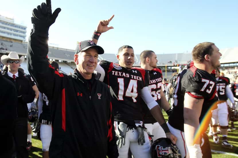 Texas Tech head coach Tommy Tuberville celebrates with his players as the school song is...