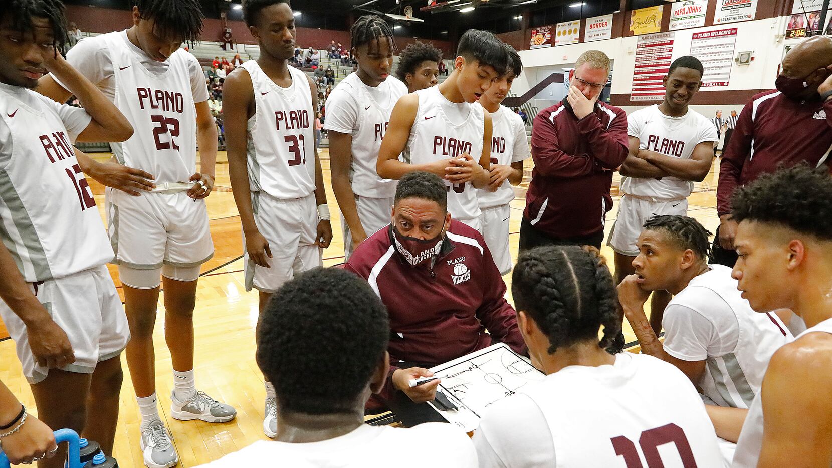 Plano Senior High School head coach Dean Christian draws up a play during a time out in the...