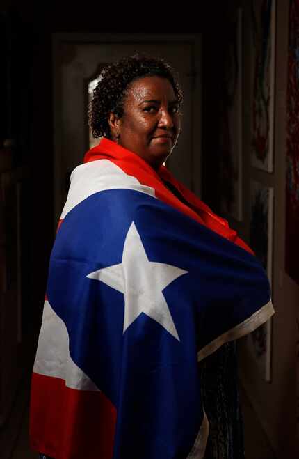 Sara Rosado, draped in a Puerto Rican flag, lives in Arlington. 