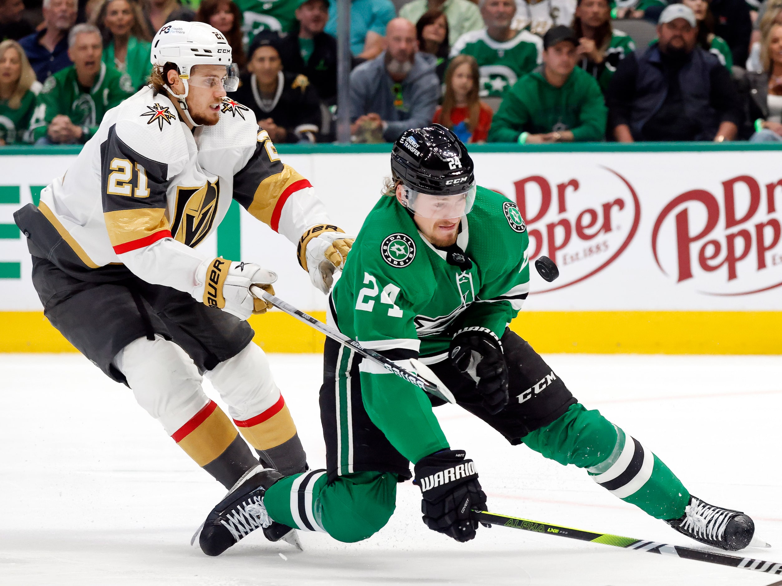 Dallas Stars center Roope Hintz (24) tries to keep the puck in front of him as he competes...