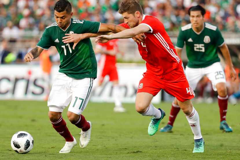 El mexicano Jesús Manuel Corona, izquierda, defiende el balón ante el galés Ben Davies en el...