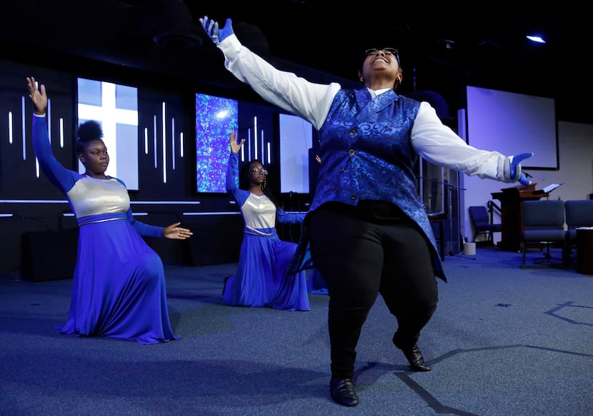 Daisy Herron (right), among the members of The Restored dance ministry, runs through a...