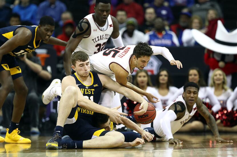Texas Tech's Davide Moretti (25) and West Virginia's Logan Routt battle for a loose ball...