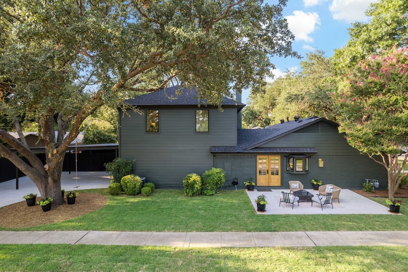 Small patio on the side of a dark green house