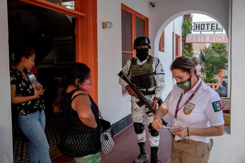 Mexican immigration officials and the Mexican National Guard talk to migrants at the Hotel...