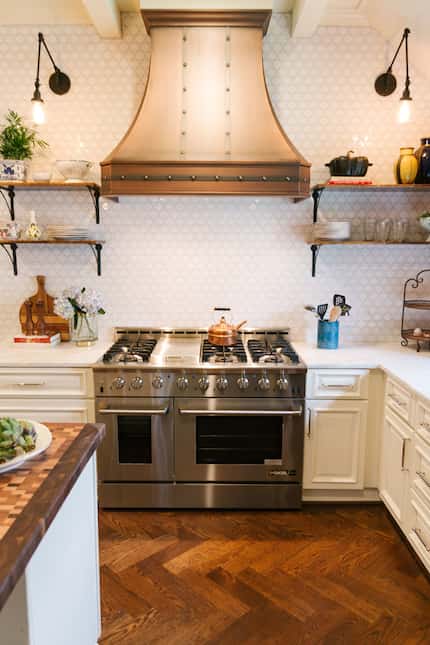 There's no denying the Parisian influence with a custom copper vent hood over a professional...