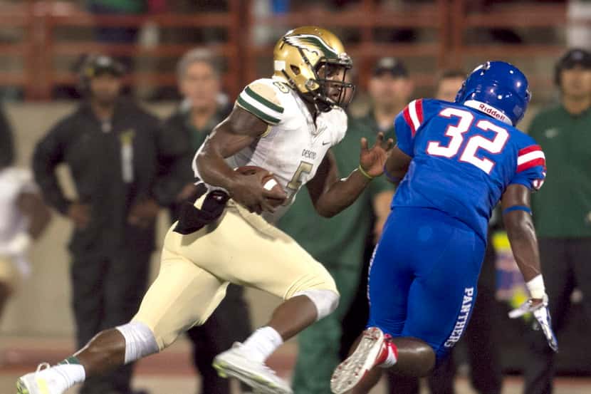 DeSoto quarterback Tristen Wallace (5) scampers for a first down as Duncanville linebacker...