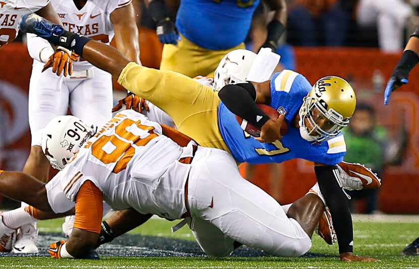 UCLA Bruins quarterback Brett Hundley (17) lands on his left hand after being tackled by...