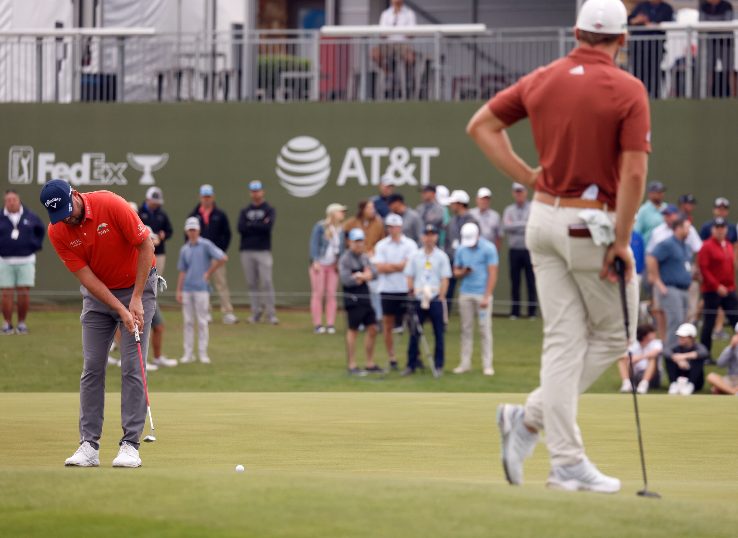 Marc Leishman putts on the 16th hole as Sam Burns watches during round 1 of the AT&T Byron...