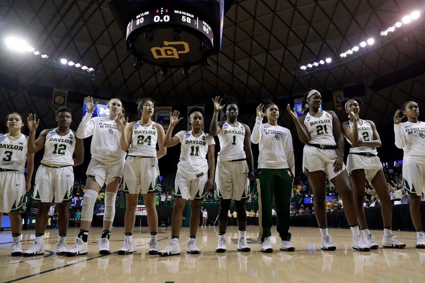 The Baylor basketball team celebrate after their win in a second-round game against Michigan...