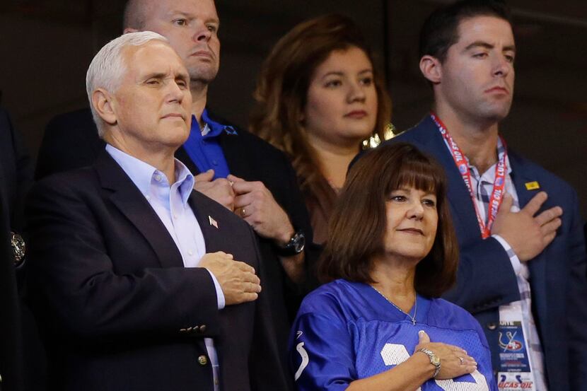 Vice President Mike Pence and his wife, Karen, stand during the playing of the national...
