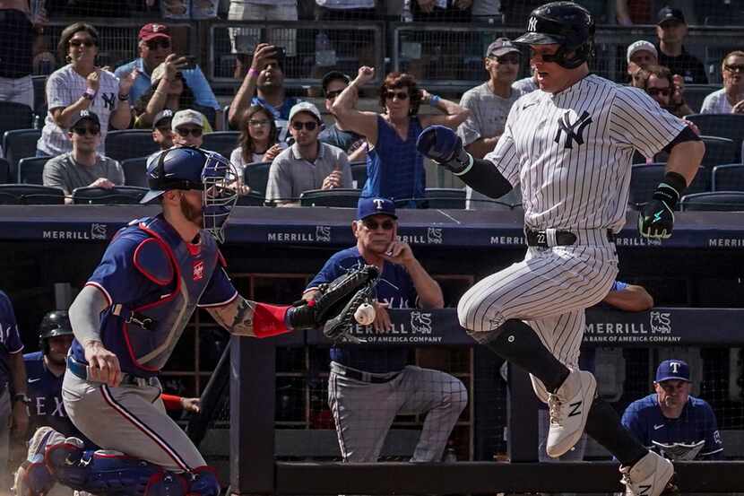 New York Yankees' Harrison Bader beats a throw to Texas Rangers catcher Jonah Heim and...