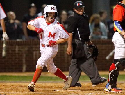 Marcus High School left fielder Nick Mazzola (1) scores a run in the first inning as Marcus...