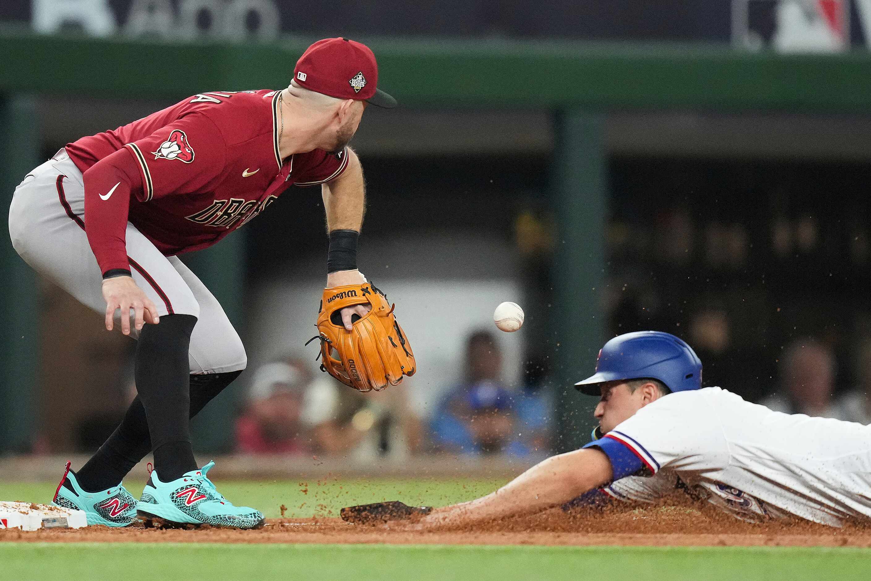 Texas Rangers' Corey Seager slides in safely past Arizona Diamondbacks third baseman Evan...