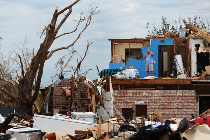 MOORE, OK - MAY 23: Steve Gerberth takes a phone call from the second story of his destroyed...