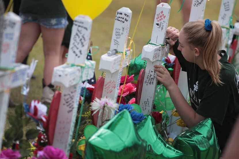SANTA FE , TX - MAY 21:  Mourners visit a memorial in front of Santa Fe High School on May...