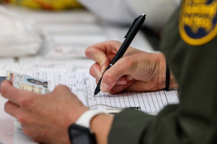 A Border Patrol officer processed migrants from Venezuela after they crossed the Rio Grande...