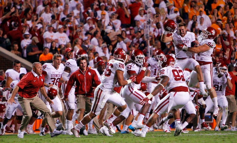 Oklahoma players celebrate a 31-24 double overtime victory in an NCAA college football game...