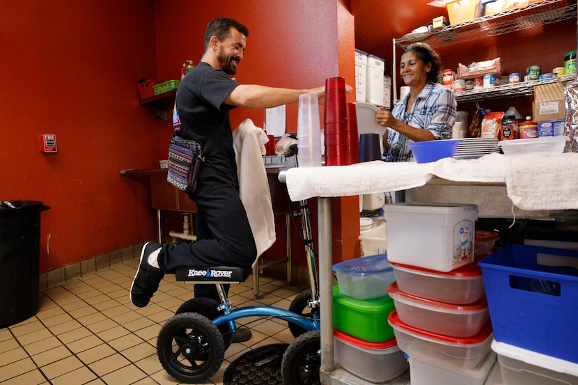 Gabriel Ribeiro (left), a migrant from Espírito Santo, Brazil, cleans dishes with another...