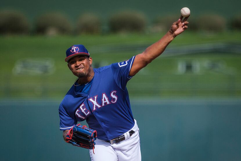 Texas Rangers pitcher Yohander Mendez pitches during the first inning of a spring training...