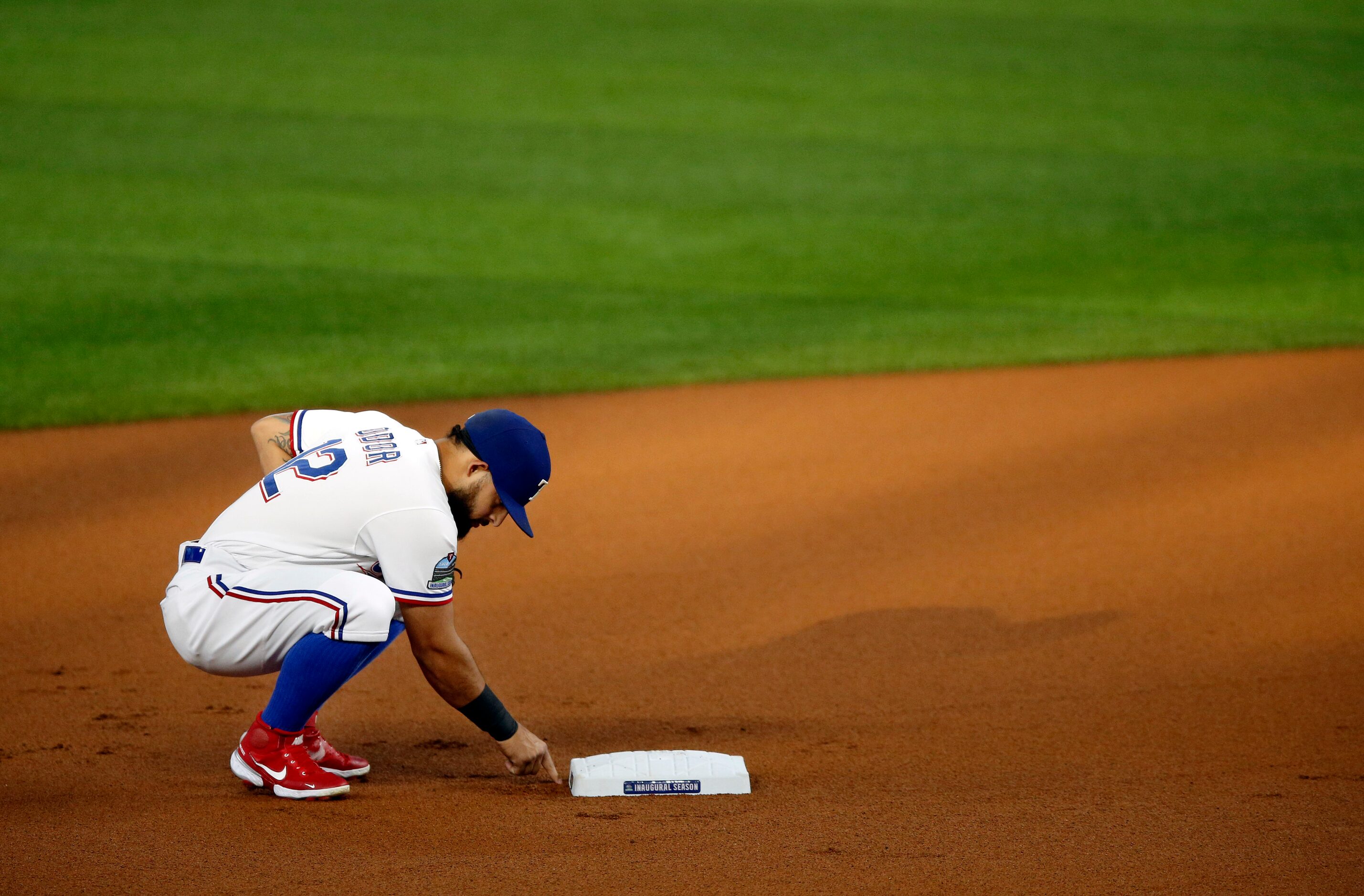 Texas Rangers second baseman Rougned Odor (12) writes in the dirt behind the base before...