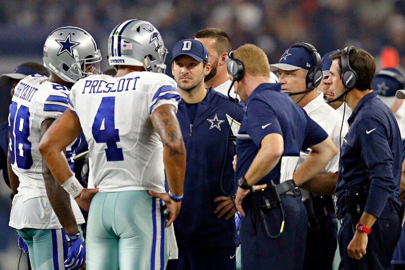 Dallas Cowboys quarterback Tony Romo (center) talks to quarterback Dak Prescott (4) in a...