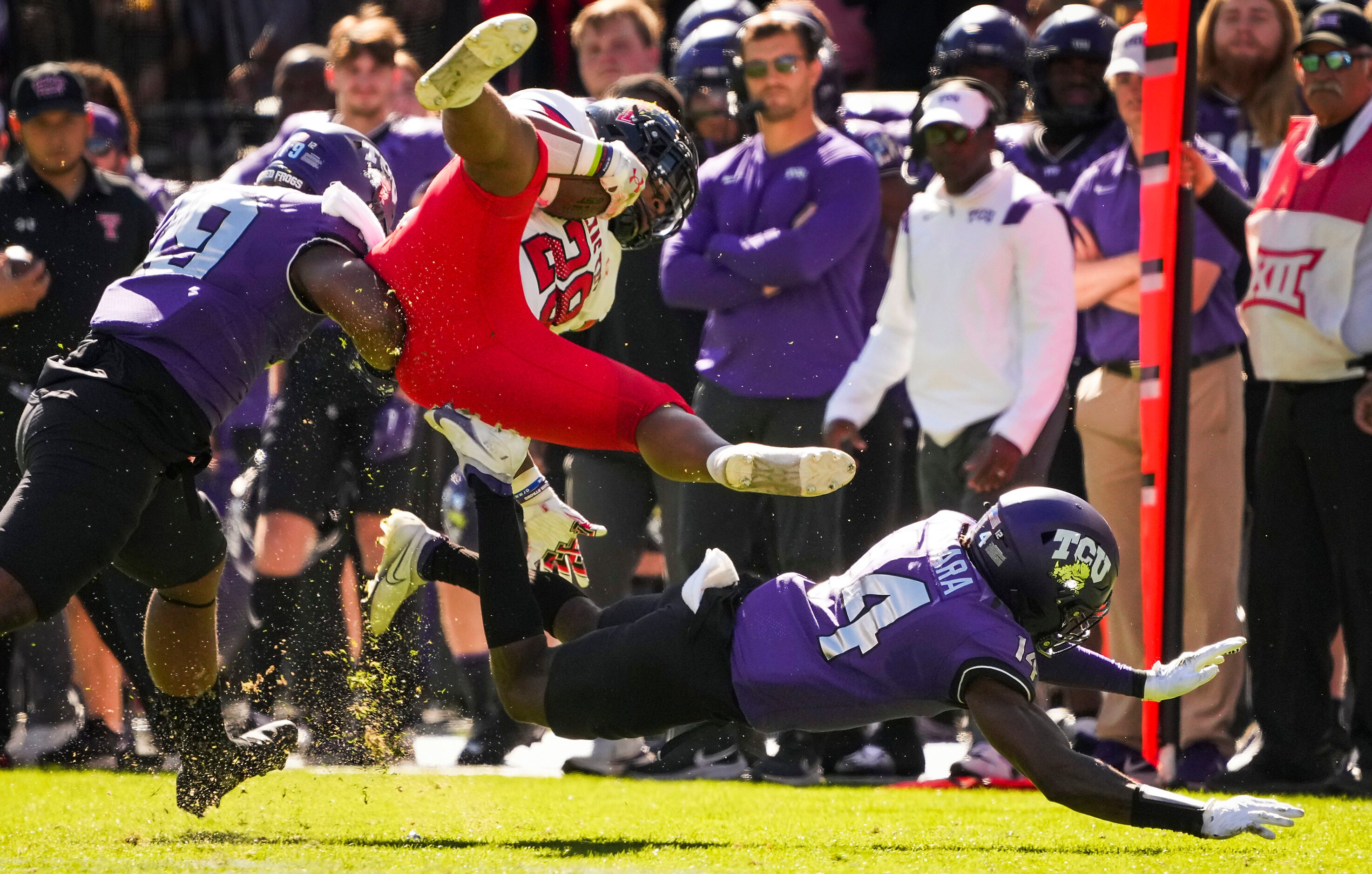 Texas Tech running back Tahj Brooks (28) is knocked off his feet by TCU safety Abraham...